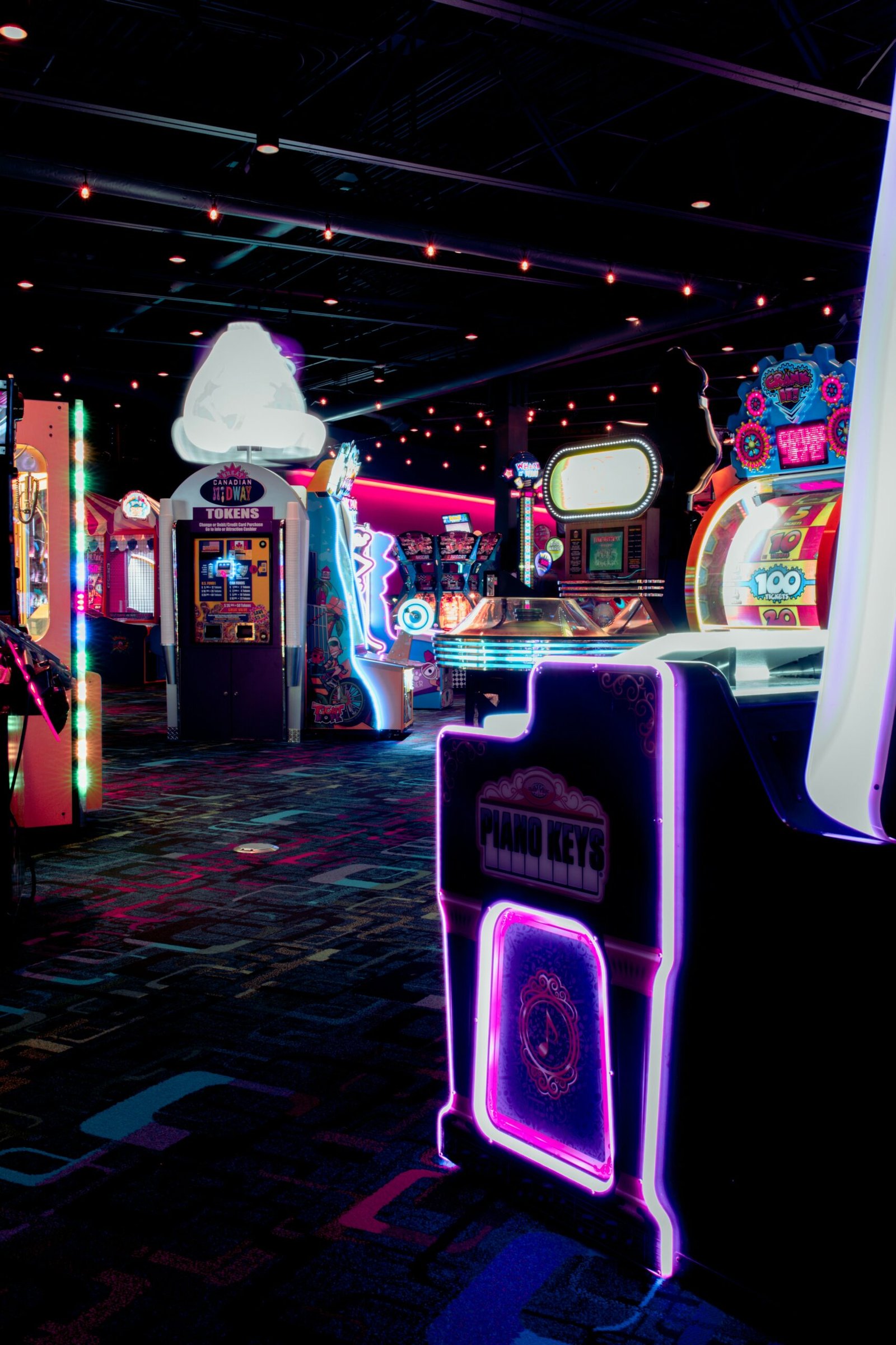 Sala llena de máquinas arcade iluminadas con luces de neón