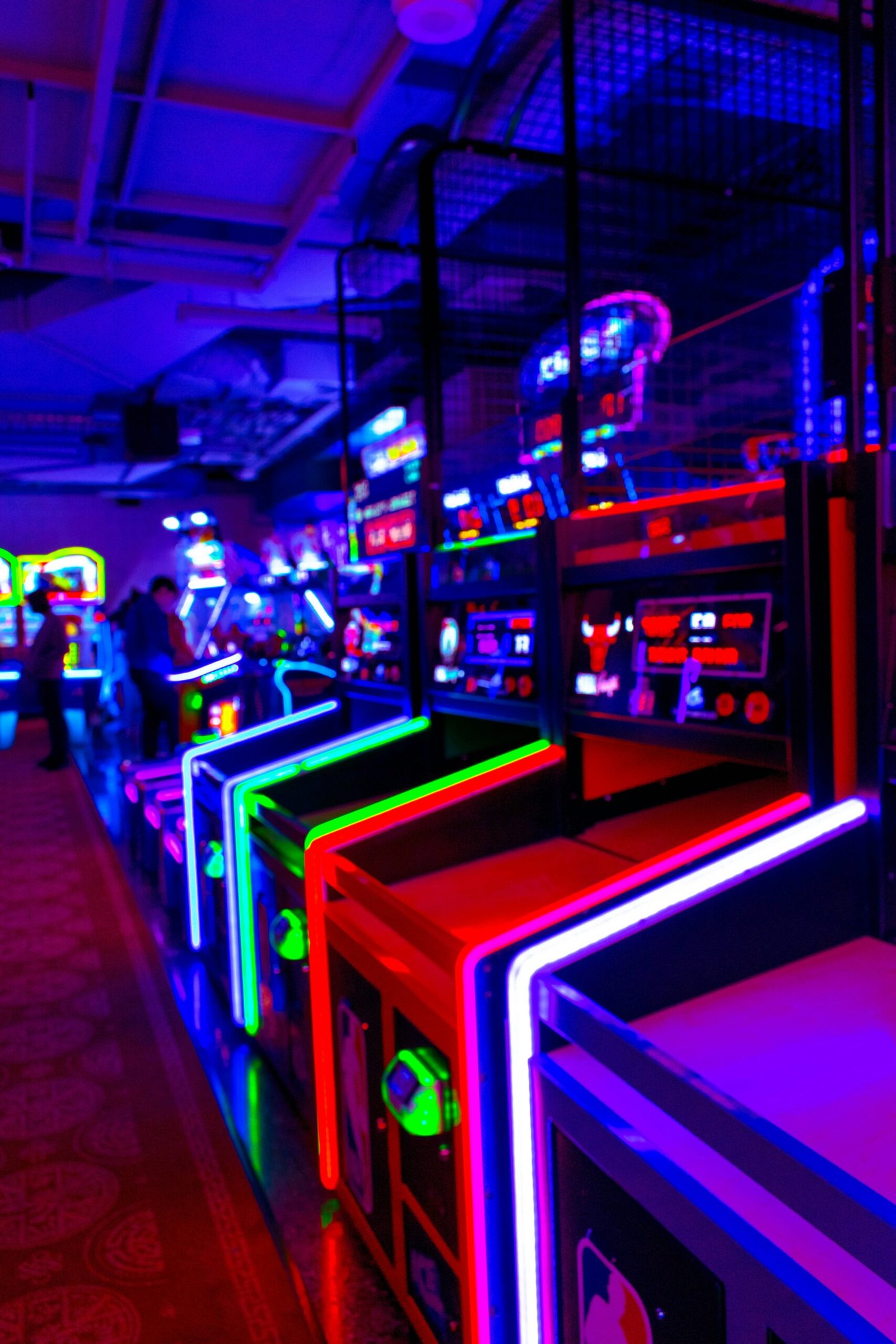 Máquinas arcade iluminadas alineadas en una sala de juegos