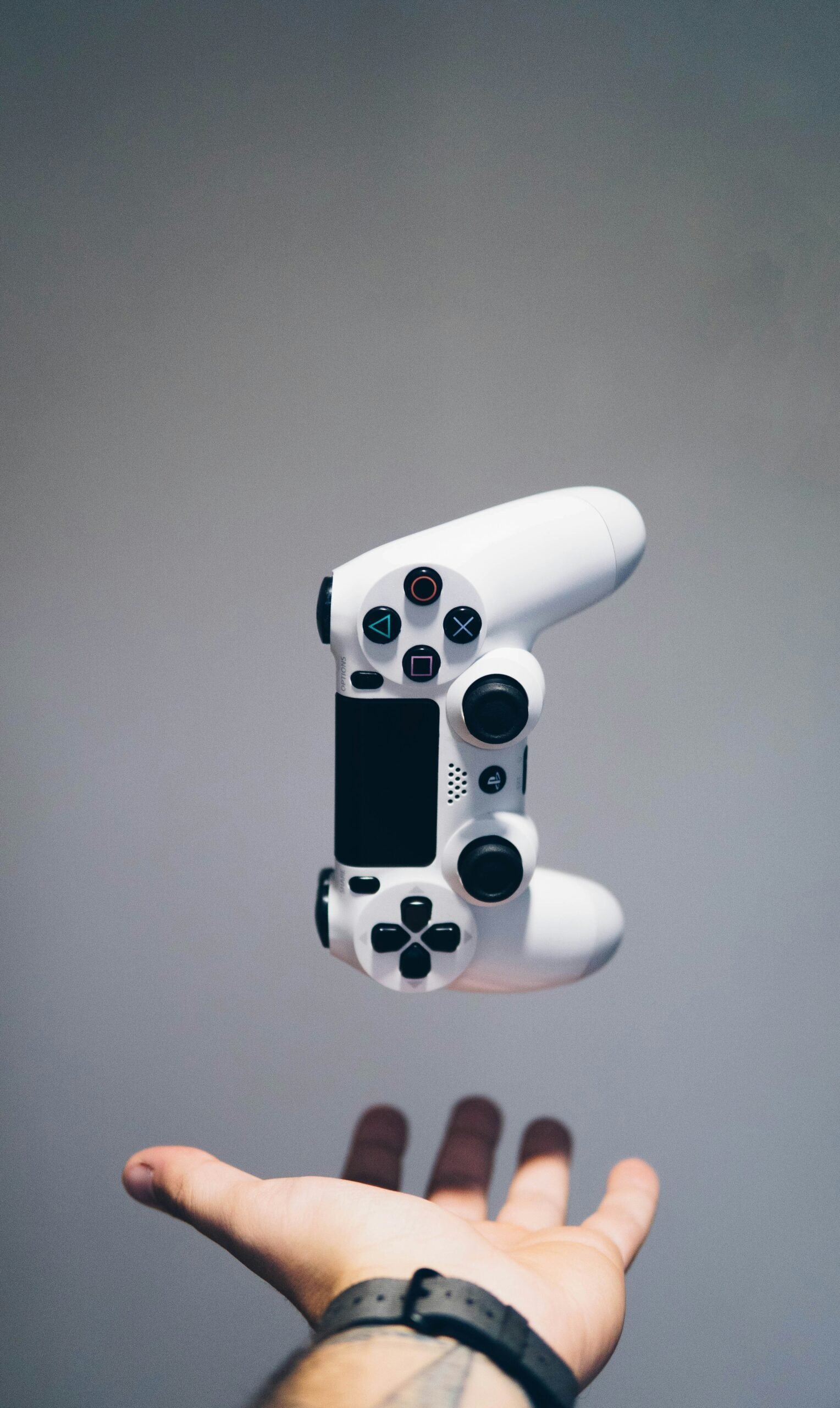 Control de videojuegos blanco sostenido sobre la palma de una mano