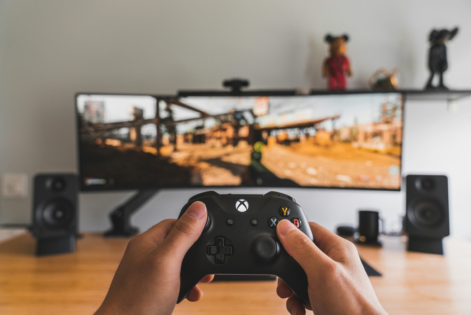 Persona sosteniendo un control de videojuegos negro con ambas manos